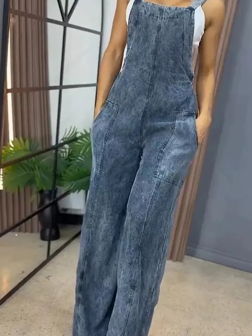 Denim wide-leg overalls in vintage wash blue with bib front and pockets.