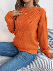 Orange acrylic sweater with chevron knit detail and eyelet accents.