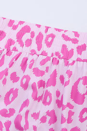 Pink leopard print shorts with elastic waistband and scalloped hem detail.