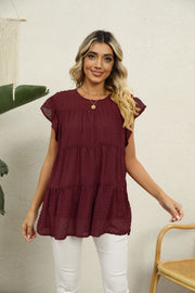 Swiss dot flutter sleeve tiered blouse in Brick Red with round neckline.