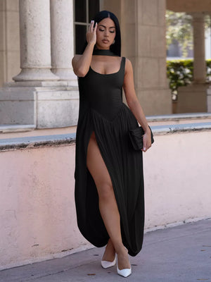 Black scoop neck maxi dress with high slit and draped skirt detail.