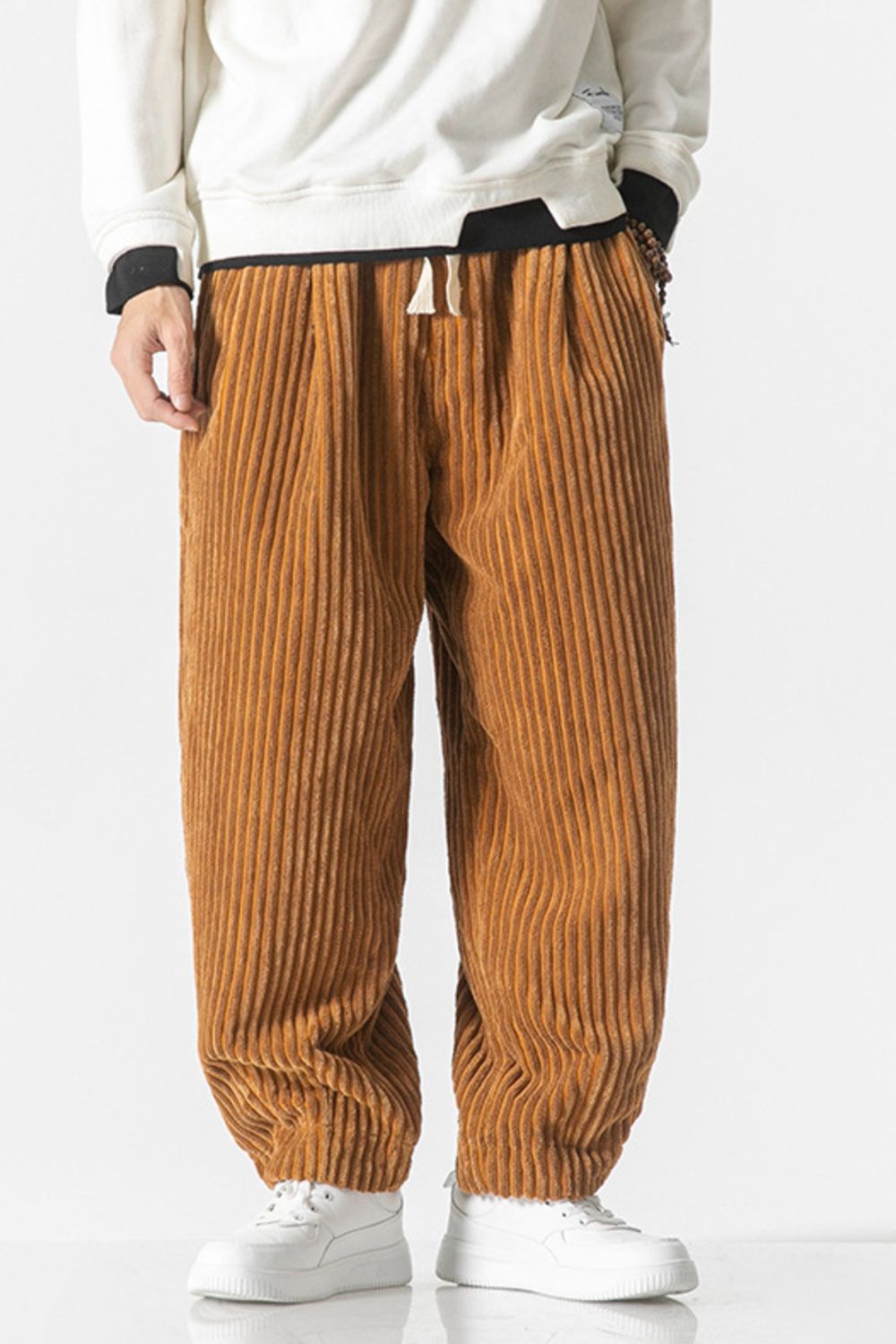 Orange corduroy wide-leg cargo pants with drawstring waist and vertical wale texture.