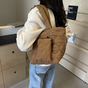 Quilted shopper bag in coffee brown with diamond pattern and front zip pocket.