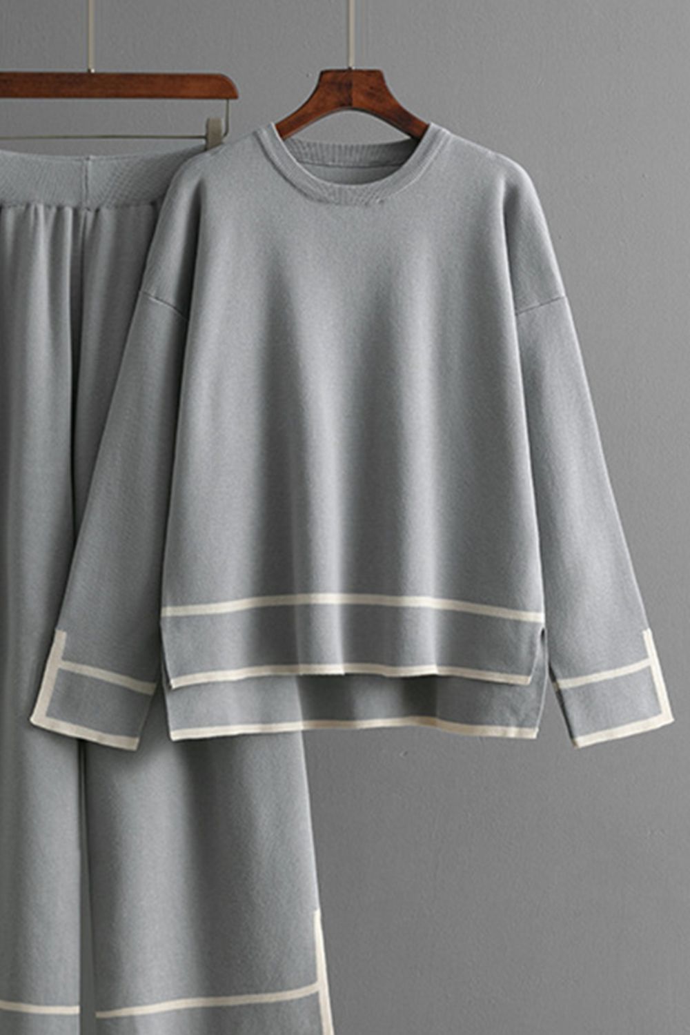 Gray acrylic loungewear set with round neck top and sweater pants, featuring contrast stripe details.