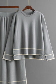 Gray acrylic loungewear set with round neck top and sweater pants, featuring contrast stripe details.