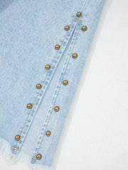 Light wash denim jeans with studded side slits and frayed hem detail.