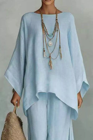 Light blue polyester two-piece set with flowing top and wide-leg pants, styled with layered necklace.