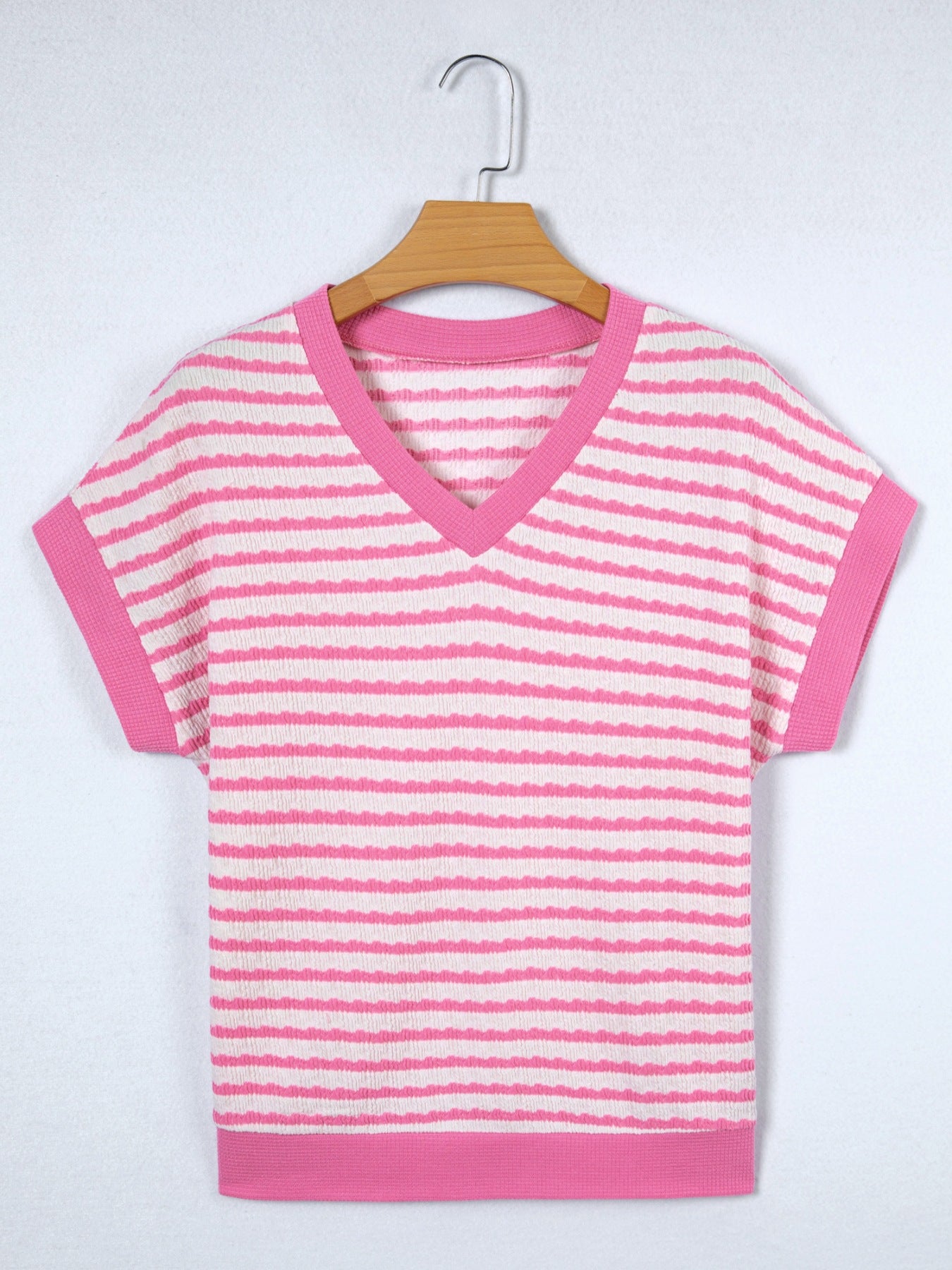 Textured pink and white striped V-neck t-shirt with short sleeves and pink trim.