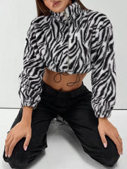 Plush cropped zebra print jacket in black with drawstring closure and zip front.