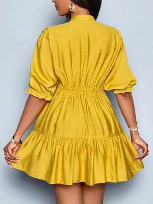 Yellow tiered mini dress with cinched waist, puff sleeves, and ruffled hem.