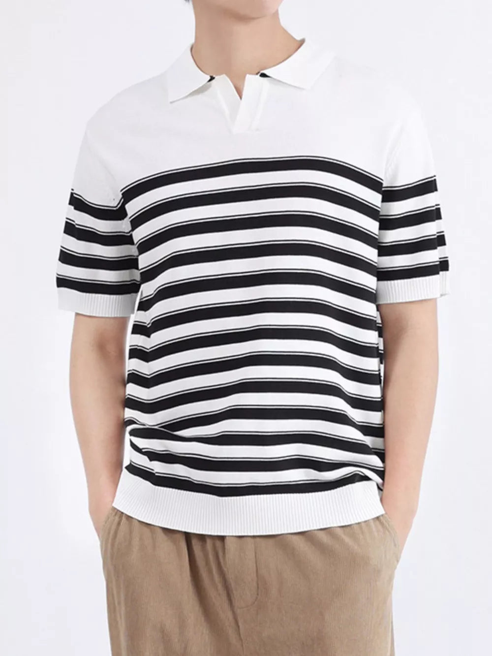 Men's black and white striped knit polo shirt with short sleeves and a collar.