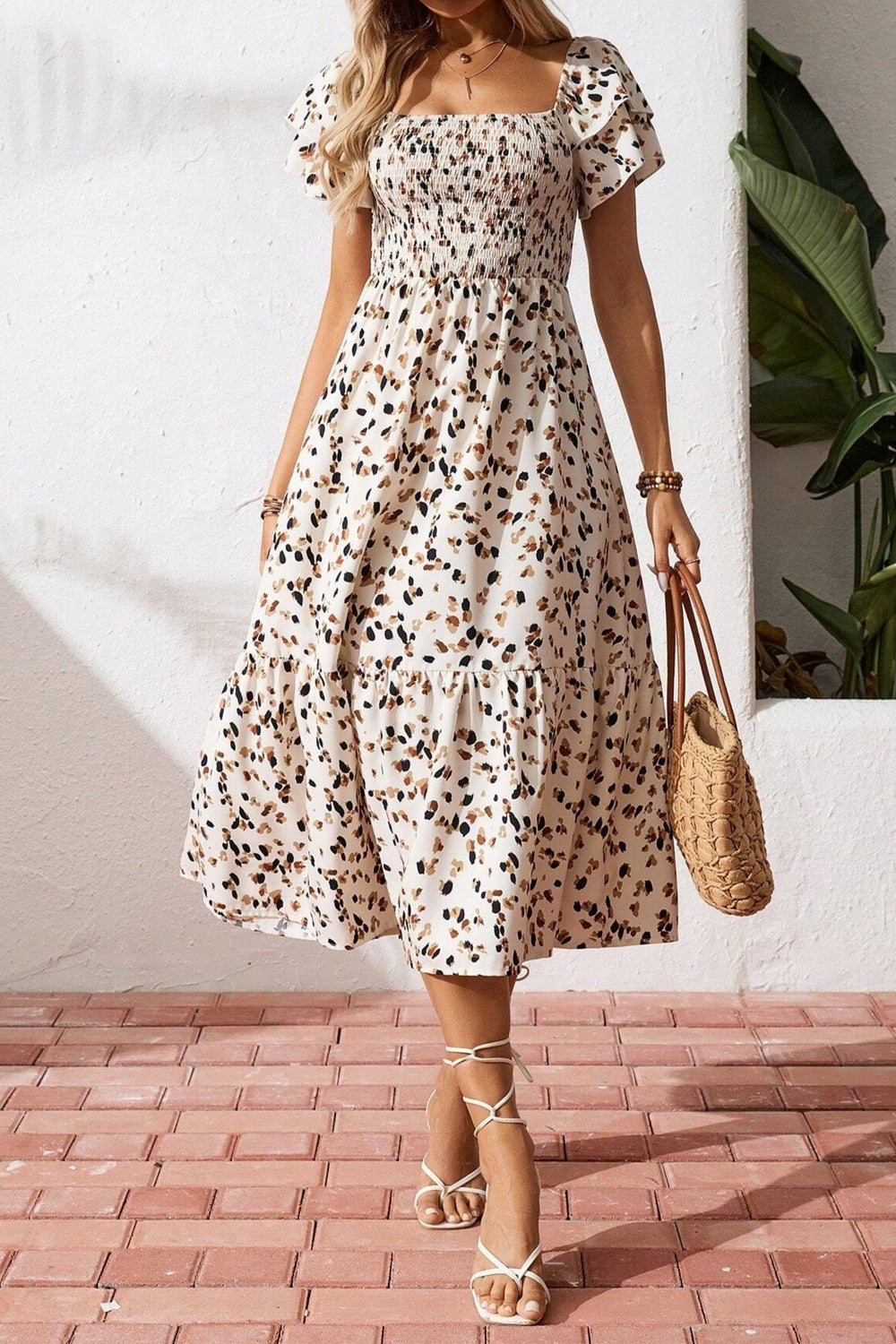 Tiered ruffle sleeve midi dress with abstract print, smocked bodice, and tiered skirt.