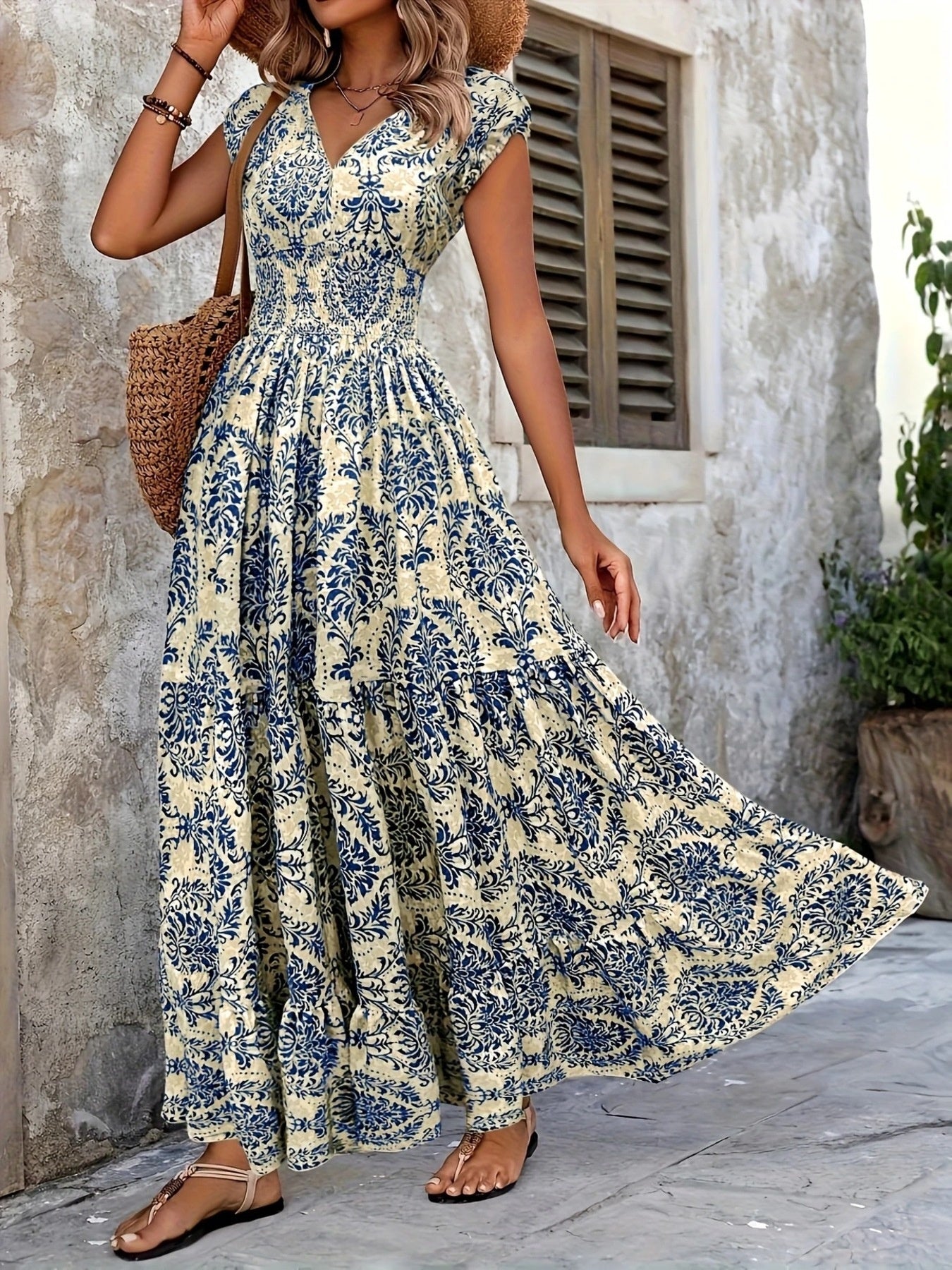 Maxi dress with blue damask print, V-neck, cap sleeves, and tiered skirt.