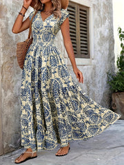 Maxi dress with blue damask print, V-neck, cap sleeves, and tiered skirt.