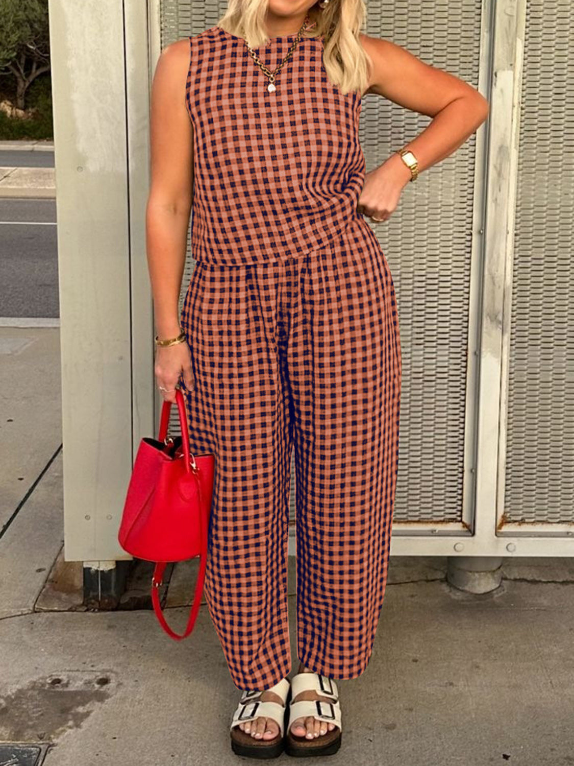 Orange gingham cropped tank and tapered trousers set styled with a red bucket bag.