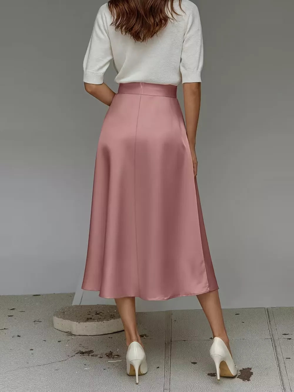 Pink satin A-line midi skirt with pockets, shown from the back.