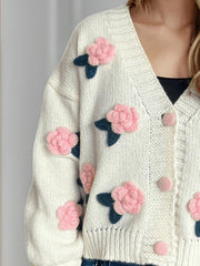 White knit cardigan with pink embroidered rose appliqués and button front.