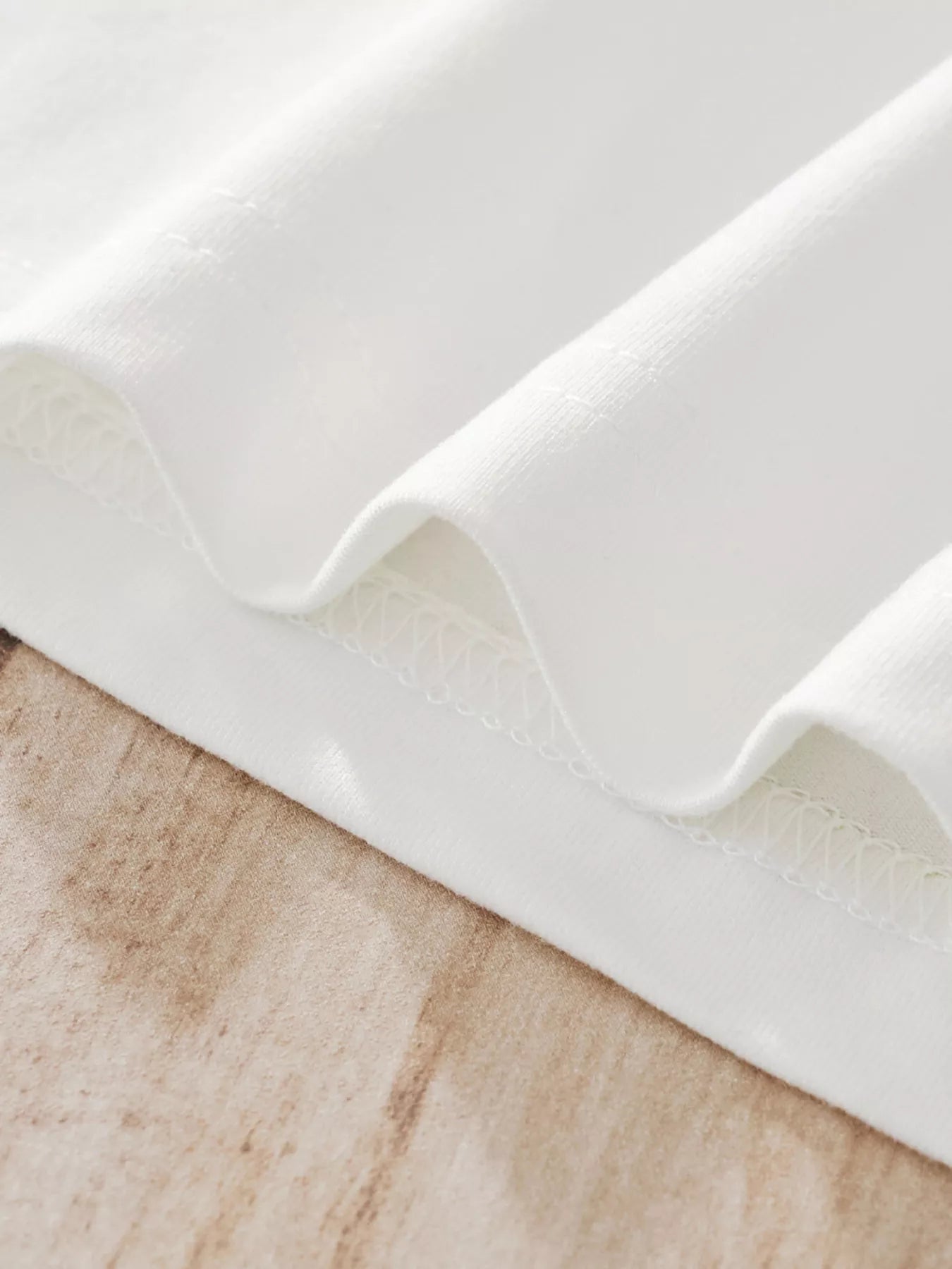 White children's pajama fabric detail showing textured stitching and soft material.