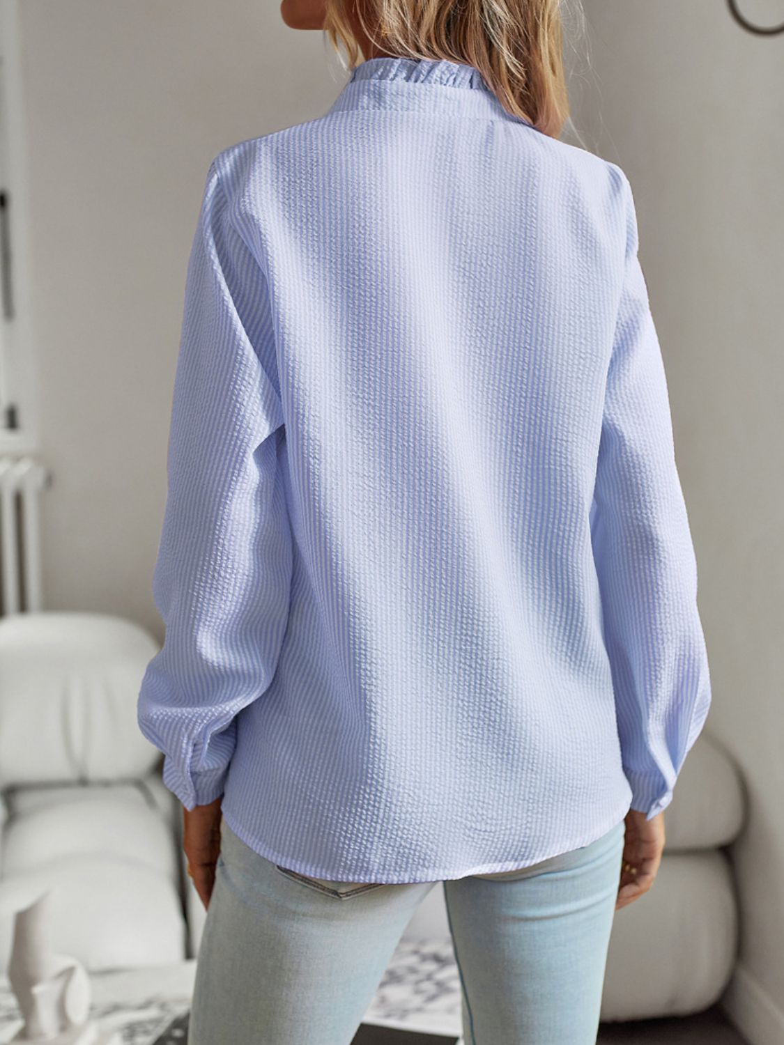 Light blue textured blouse with ruffle collar and long sleeves