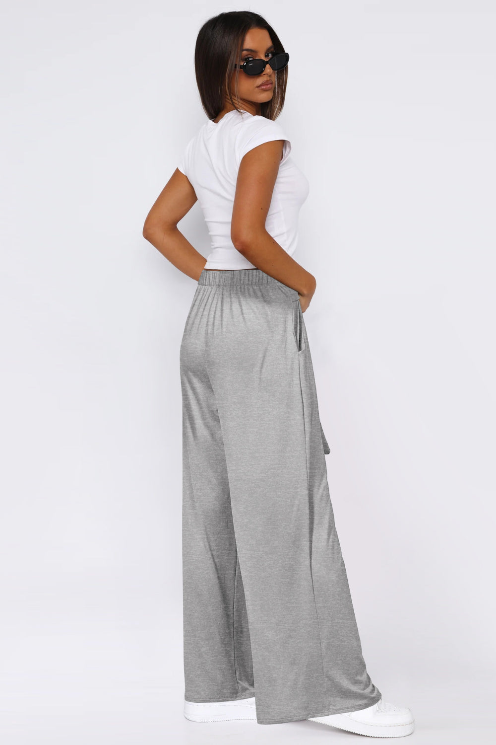 Soft drape palazzo trousers in light gray with a tie detail and elastic waist.