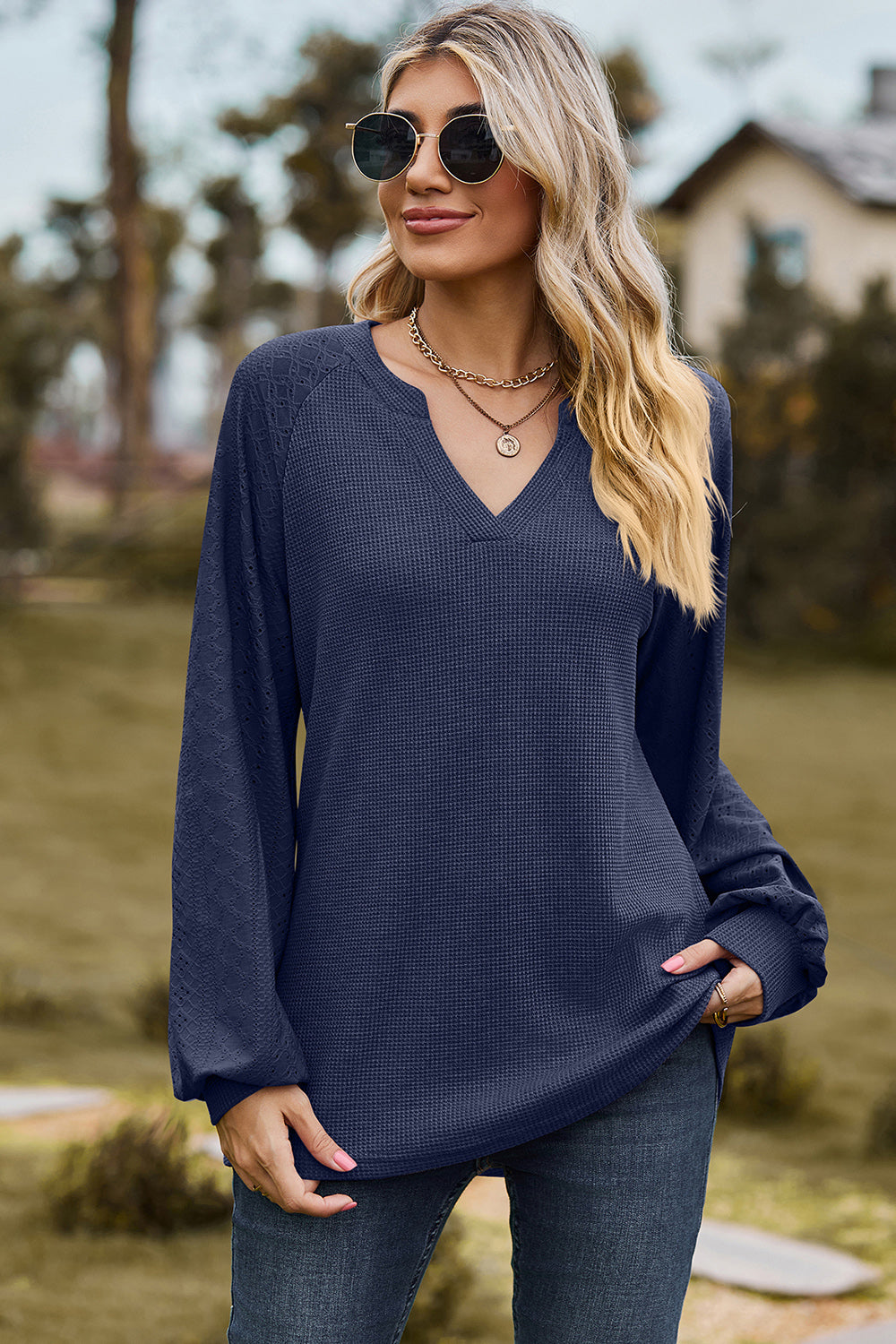 Dark blue waffle knit raglan v-neck top with textured sleeves.