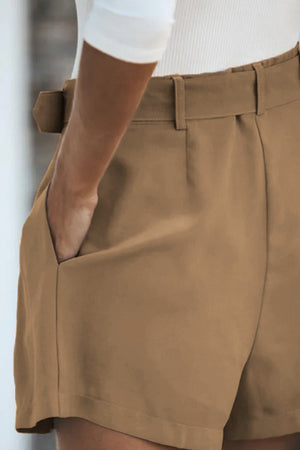 Camel pleated shorts with a belted waist and pockets, part of a blazer set.