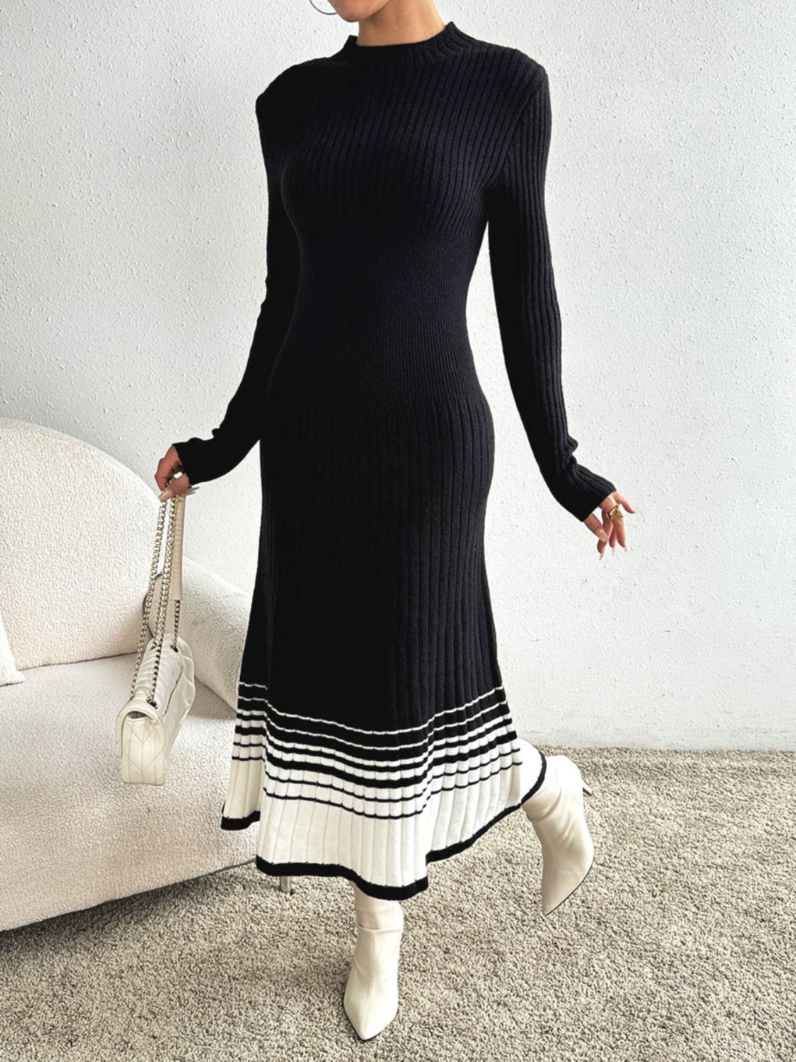 Black ribbed knit midi dress with contrast striped hem and long sleeves.