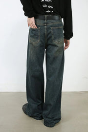 Faded denim wide-leg trousers in dark, with a relaxed fit and visible pocket details.