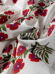 V-neck mini dress in white cotton with a red and purple floral print and green leaves.