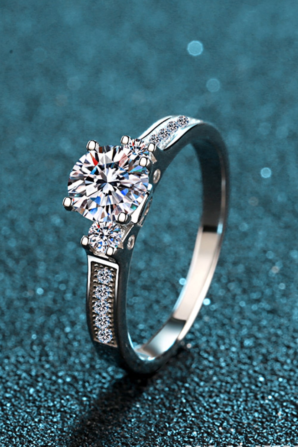 Silver rhodium engagement ring with a large solitaire and pavé band.