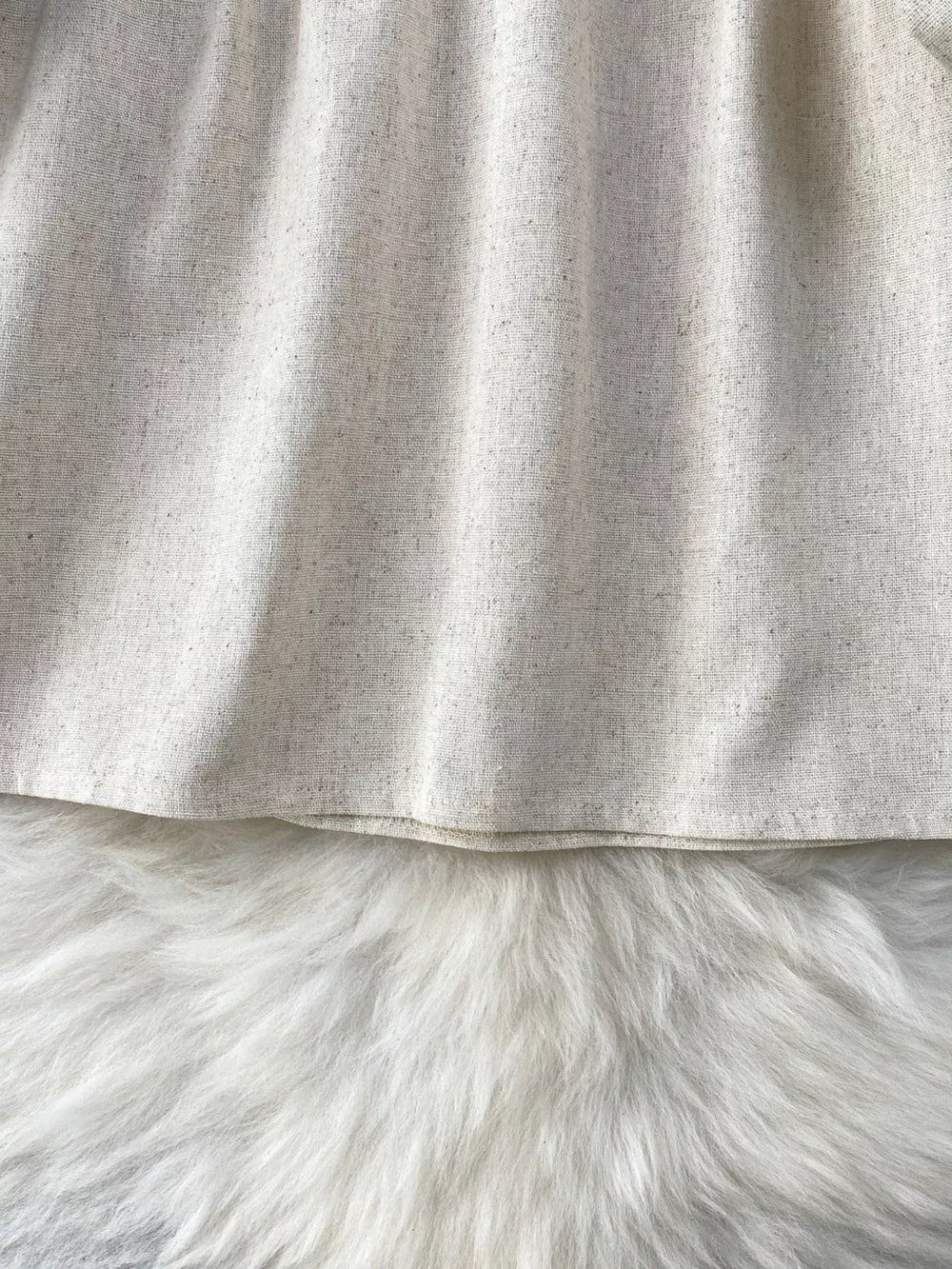 Cream tie-neck blouse with textured fabric and delicate embroidery detail