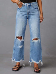 Chic distressed blue denim maternity flare jeans with raw hem and knee rips.