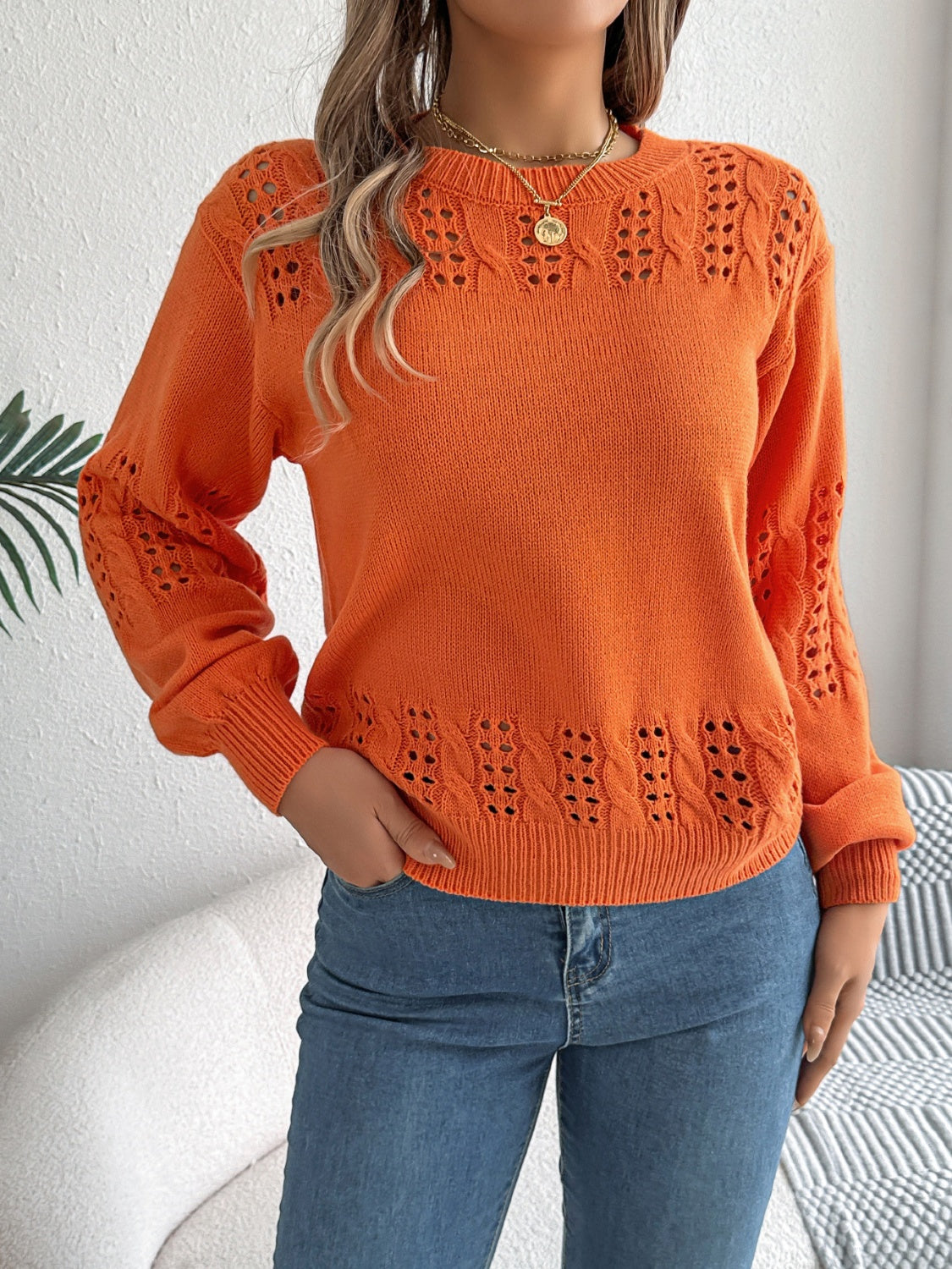 Orange knit sweater with openwork details on sleeves and hem, crew neck, long sleeves.