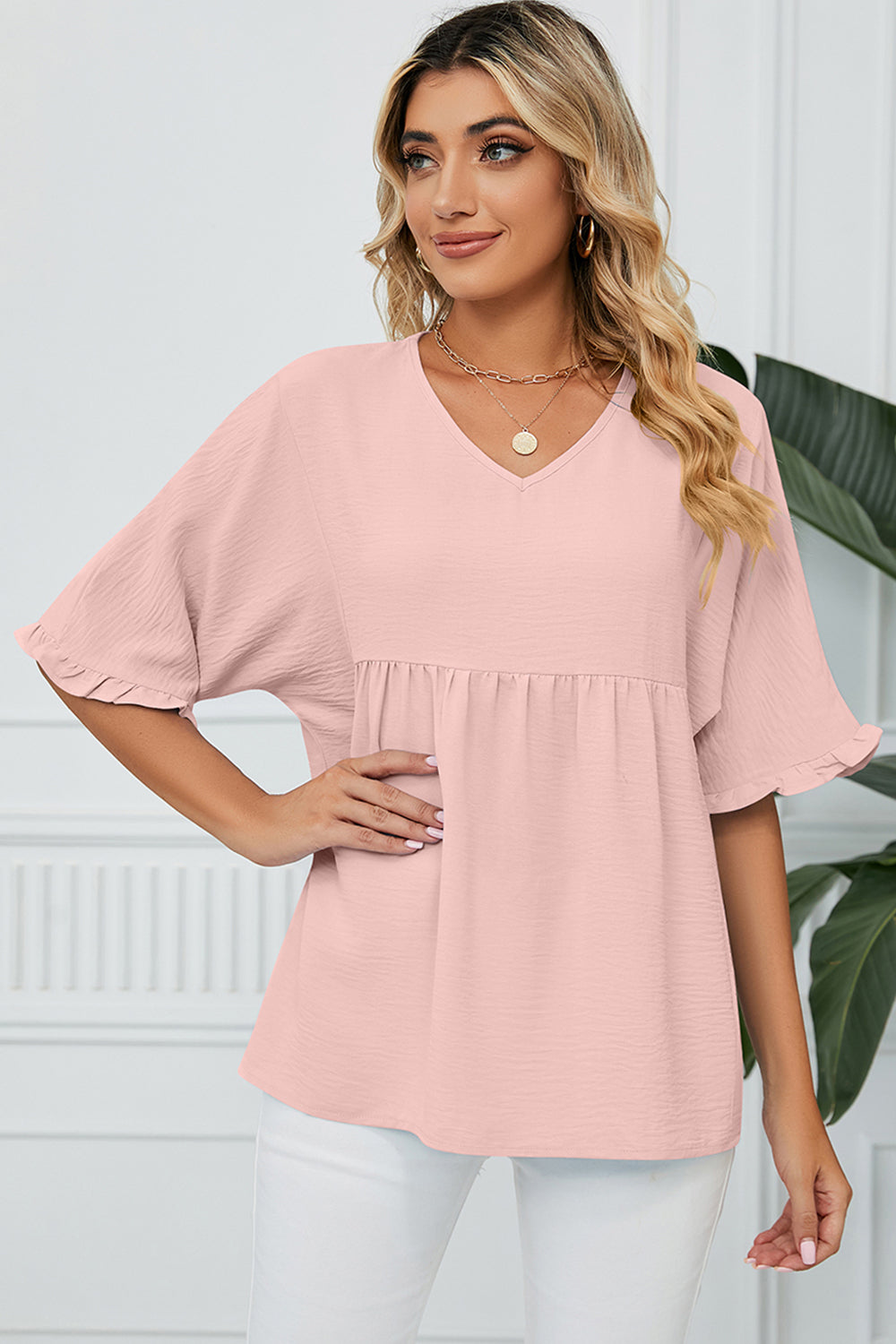 Gathered yoke blouse in watermelon pink with flutter sleeves and a v-neckline.