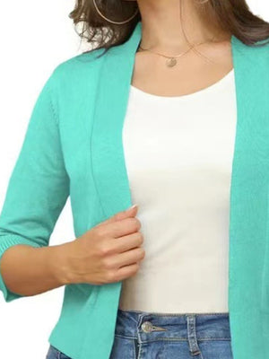 Teal open-front cropped cardigan with elbow sleeves, worn over a white top.