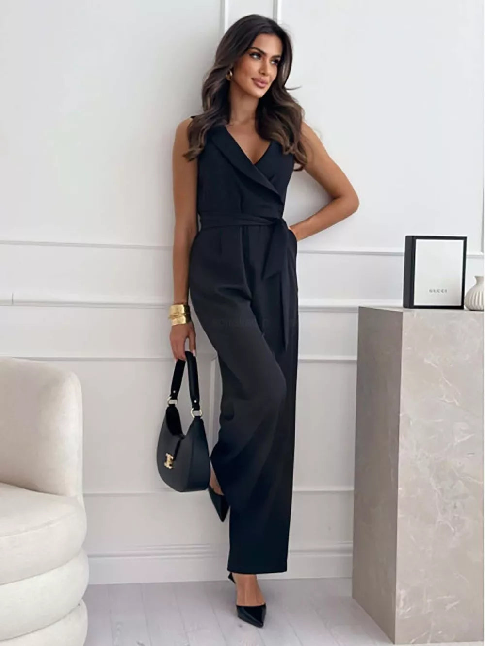 Black wrap-front wide-leg romper with belted waist and V-neck.