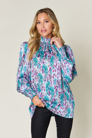 High neck abstract print blouse in sky blue and red-violet with long sleeves.