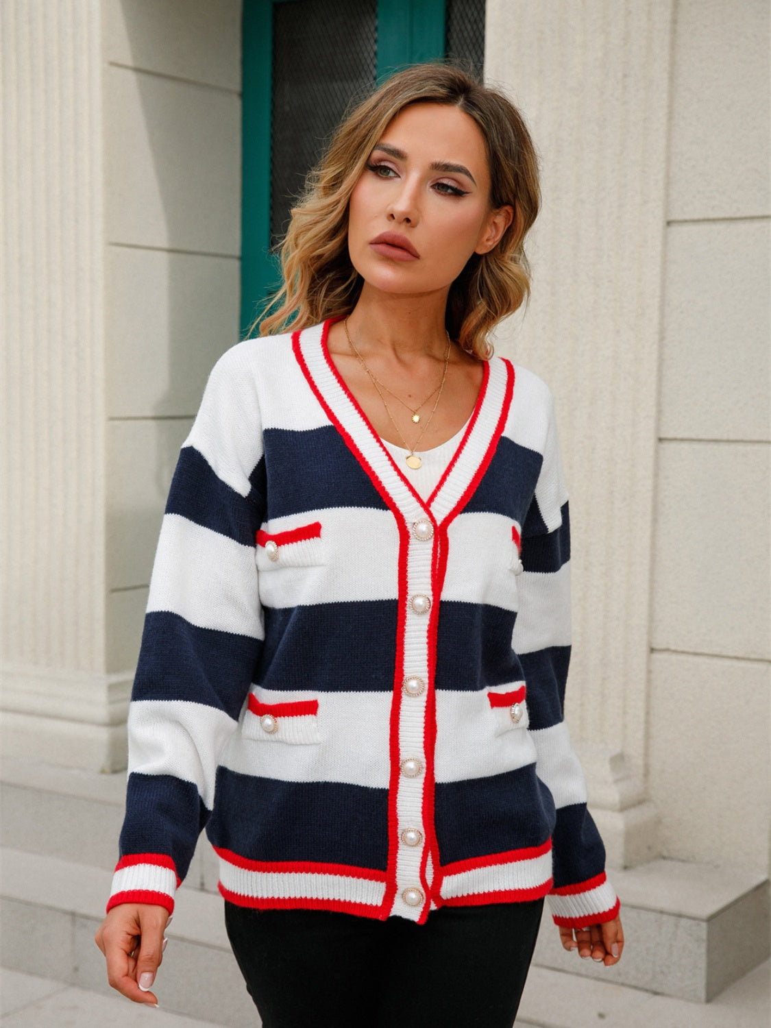 Navy and white striped knit cardigan with pearl buttons and red trim.