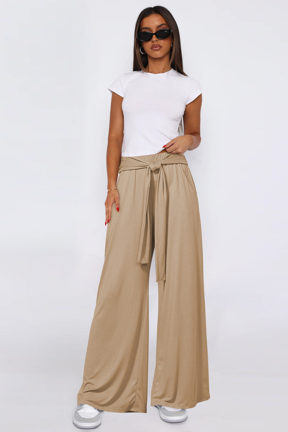 Soft drape palazzo trousers in tan with a tie waist, wide leg, and pockets.