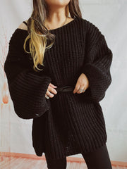 Black oversized ribbed knit sweater with belted waist and dropped shoulders.