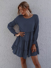 Navy blue tiered mini dress with long sleeves and ruffled details.