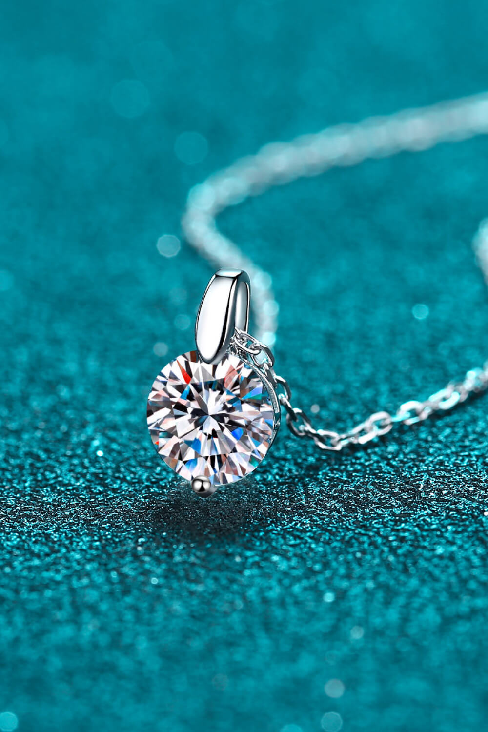 Silver solitaire moissanite pendant necklace with a round brilliant cut stone.