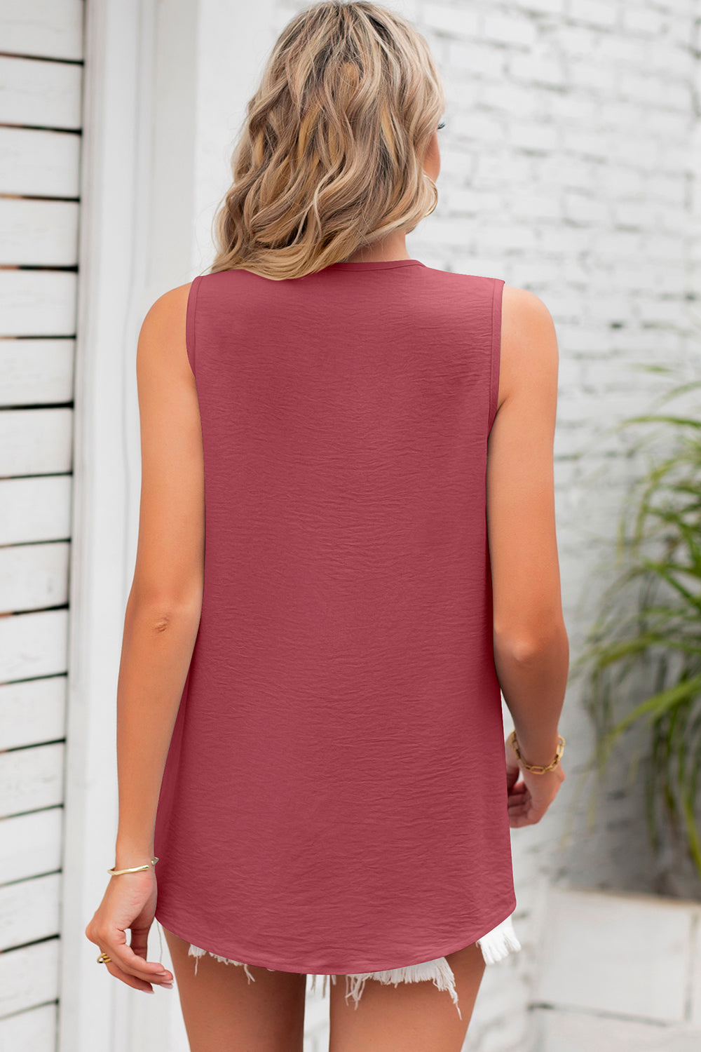 Burgundy textured sleeveless blouse with a rounded hem