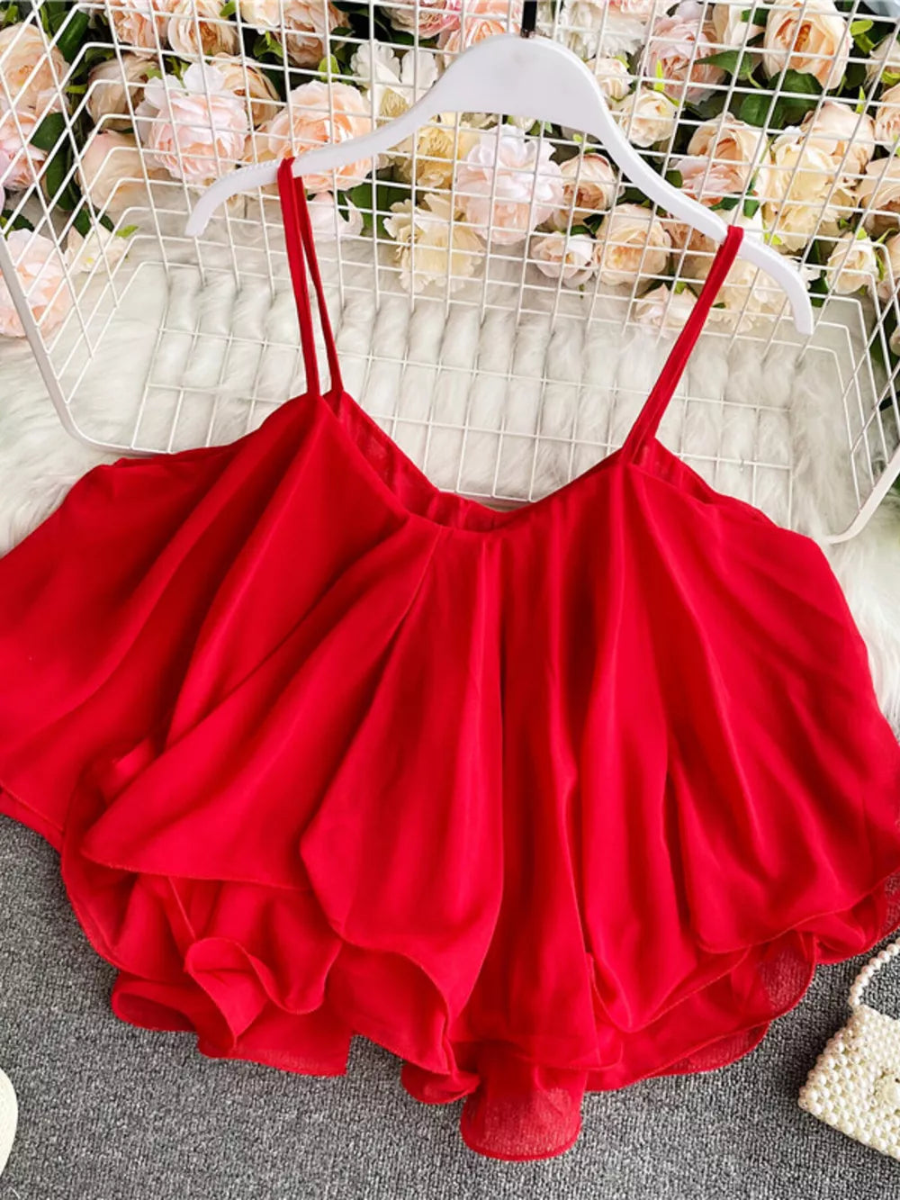Red ruffled camisole with spaghetti straps and a flowy hem