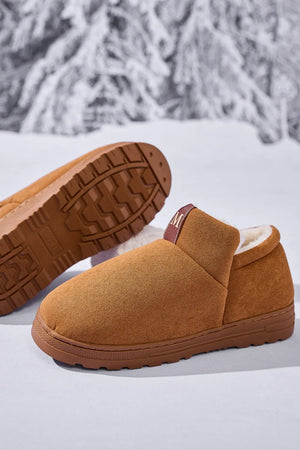 Caramel suede house booties with shearling lining and a pull tab.