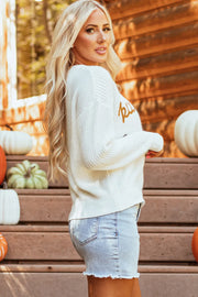 White acrylic crewneck sweater with embroidered pumpkin detail, casual autumn style.