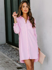 Oversized pink cotton shirt dress with button front and curved hem.