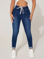 Medium wash denim joggers with a white drawcord waist and cuffed hems.