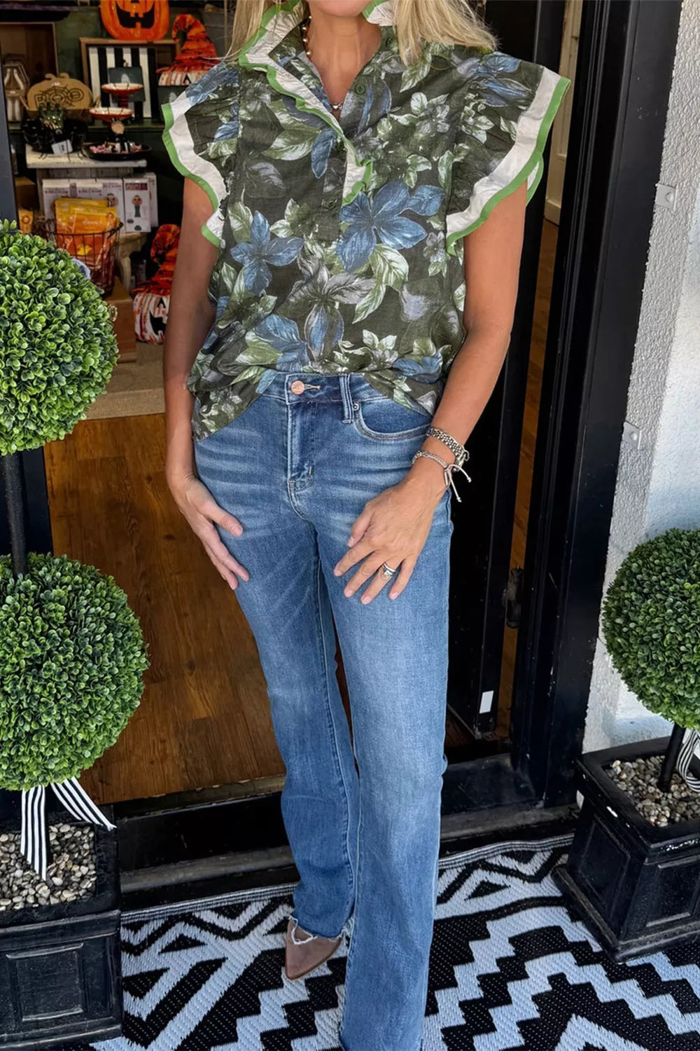 Botanical print cotton shirt with ruffle sleeves and green trim, worn with blue jeans.