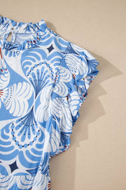 Blue and white botanical print ruffled dress with flutter sleeves and smocked details.